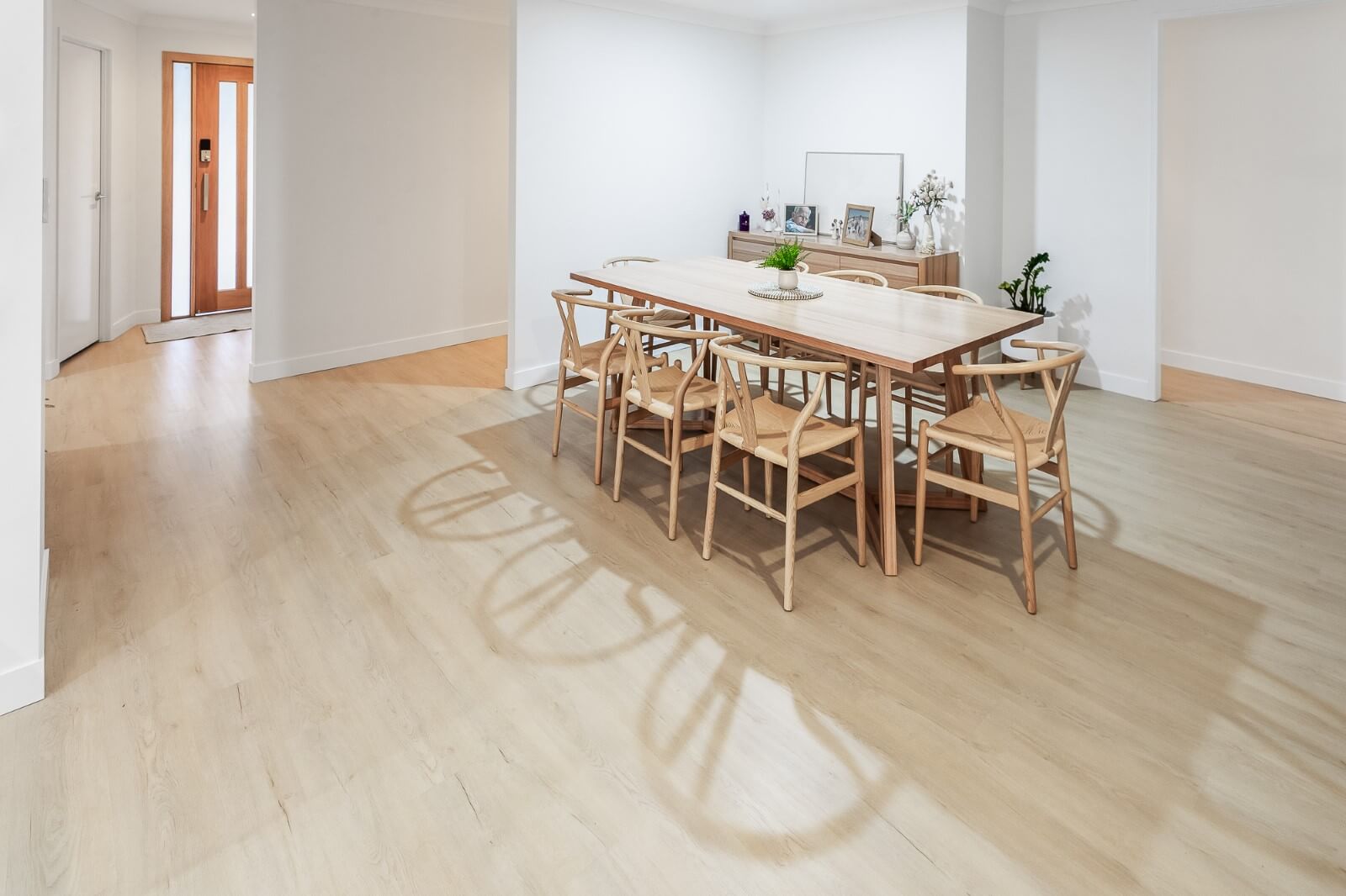 Modern dining area with wooden table and chairs on a light wood floor.